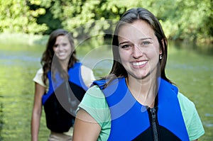 Two outdoorsy females with life jackets