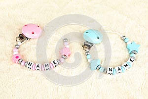 Two pacifier chains in blue and pink