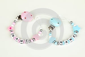 Two pacifier chains in blue and pink