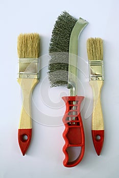 Two painting brushes and abrasive brush in the middle photo