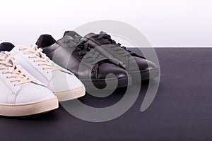 Two pair of sneakers shoes on black background. Black and white shoe.