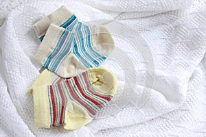 Two pairs of baby socks: blue and yellow striped