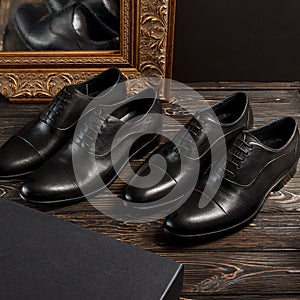 Two pairs of black color oxford men shoes with golden biedermeier picture frame