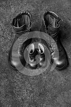 Two pairs of  black shoes on the concrete background