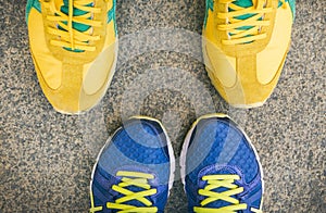 Two pairs of bright sport shoes standing in front of each other