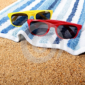 Two pairs couple sunglasses beach towel sand background