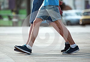 Two pairs of feet walking together men. friendships of friends photo