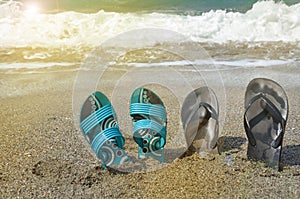 Two pairs of flip-flops on the beach, tropical holiday concept, sunlight