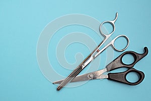 Two pairs of hairdressing scissors for cutting hair. Blue fon place for text
