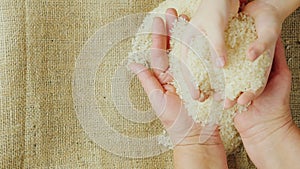 Two pairs of hands - an adult woman and child hold a grain of rice