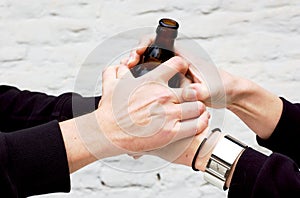 Two pairs of hands holding a dark glass