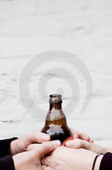 Two pairs of hands holding a dark glass