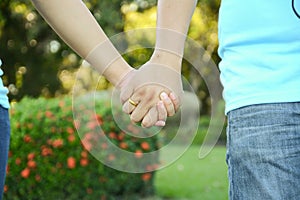 Two pairs of hands in love tenderly hold together