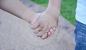 Two pairs of hands in love tenderly hold together