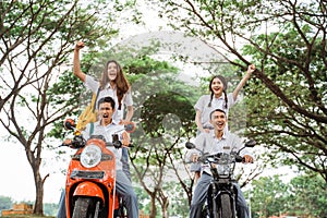 Two pairs of high school students celebrate graduation by motorbikes