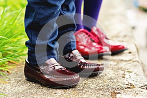 Two pairs of kids feet wearing fashion shoes