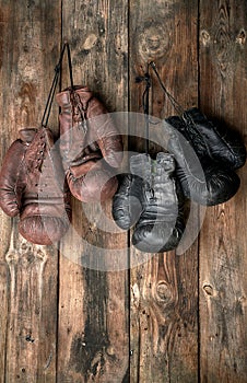 two pairs of leather vintage boxing gloves hanging on a nail