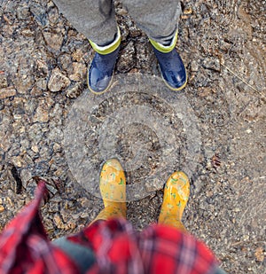 Two pairs legs in colorful gumboots