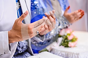 Wedded couple's hands praying photo