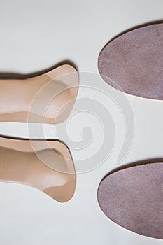 Two pairs orthopedic shoe insoles isolated on beige background