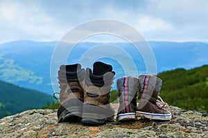 Two pairs of shoes - clean and dirty in mud stay on the rock.