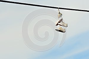 Two pairs of shoes hanging from power lines