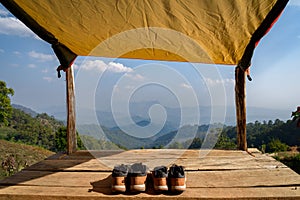 Two pairs of shoes on the wooden balcony in front of the tent with the beautiful background mountain view at Chiang Mai, Thailand