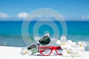 Two pairs of sunglasses on background of ocean