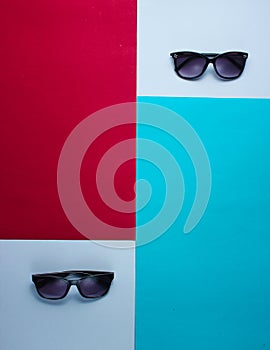 Two pairs of sunglasses on a colored paper background