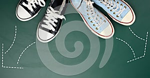 Two pairs of textile sneakers are directed in opposite directions. Quarrel and difference of opinion concept, different life paths