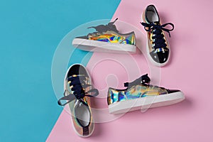 Two pairs of trendy colored women`s shoes lay on a pink and turquoise background, the concept of shopping