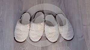 Two pairs of white slippers from sheep wool, closeup view.