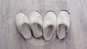 Two pairs of white slippers from sheep wool, closeup view.