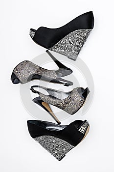 Two pairs of women\'s black high-heeled shoes with stones on a white background