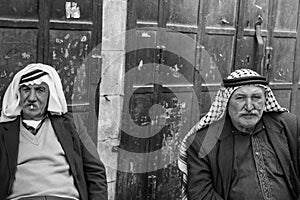 Two palestinian men are sitting having a chat an zigarettes in t