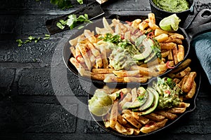 Two pans with servings of chips and guacamole photo