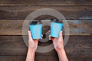 Two paper cups of coffee in hands