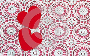 Two hearts on a white doily against a pink background