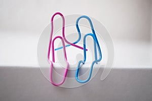 Two paperclips sitting on white desk - love concept