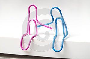 Two paperclips sitting on white desk - love concept