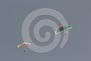 Two paragliders in blue sky