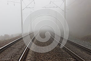 Two parallel tracks of the railway, going into the distance into fog and suspense photo