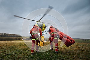 Two paramedic with safety harness running to helicopter emergency medical service