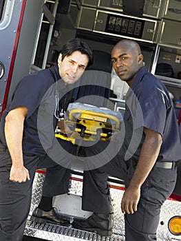 Two paramedics removing gurney from ambulance