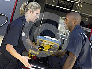 Two paramedics removing gurney from ambulance