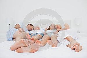 Two parents sleeping with their two children