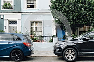 Two parked cars in front of an apartment entrance photo