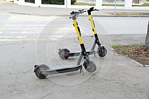 Two parked scooters in the city. Modern youth mode of transport