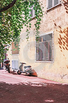 Two parked scooters in a street of Nice