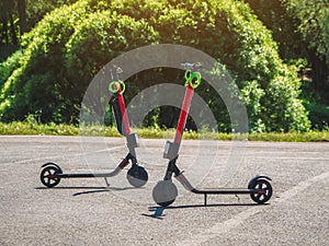 Two parked scooters in the summer city. Modern youth mode of transport